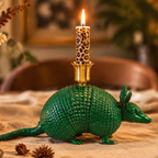 A green armadillo-shaped candle holder with a brass cup on its back, being used in a Christmas Table Setting
